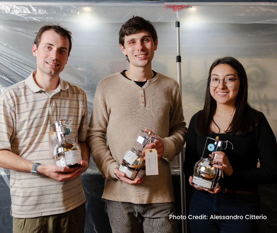 Image of three researchers holding canisters filled with natural gas.