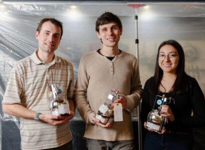 Image of three researchers holding canisters filled with natural gas.